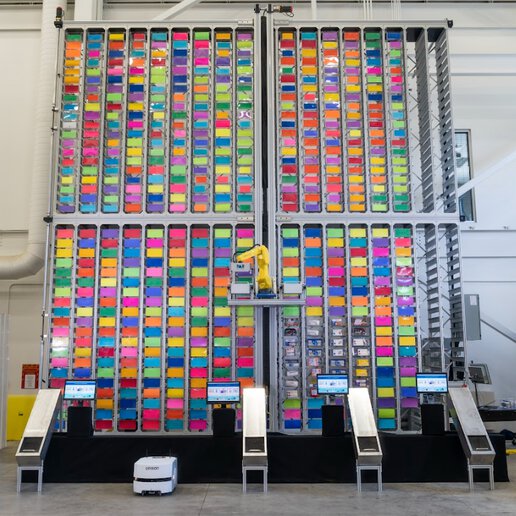Warehouse wall with multi-colored containers and PAR Systems order fulfillment system.