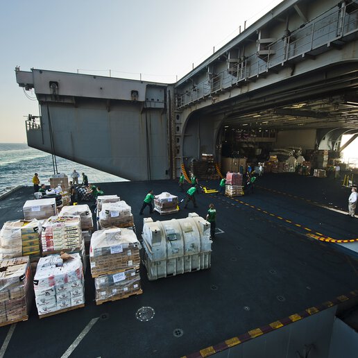 Cargo being loaded into the hangar bay and aircraft elevator on the Nimitz-class aircraft carrier USS Abraham Lincoln.