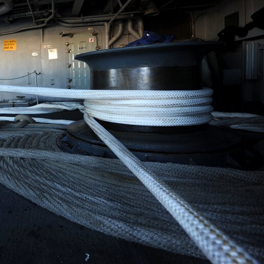 Mooring line circled around general capstone on a navy ship.