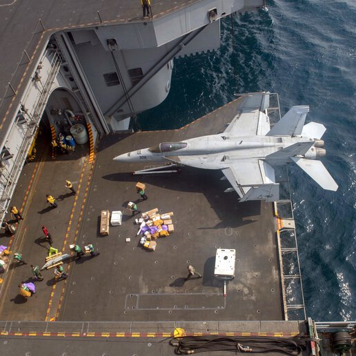 Sailors moving mail from an aircraft carrier into the hangar bar on the USS Nimitz (CVN 68).