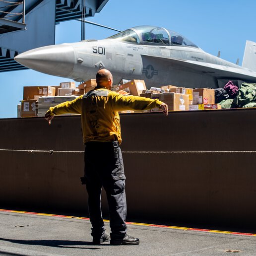 Technician operating an aircraft elevator on the flight deck.