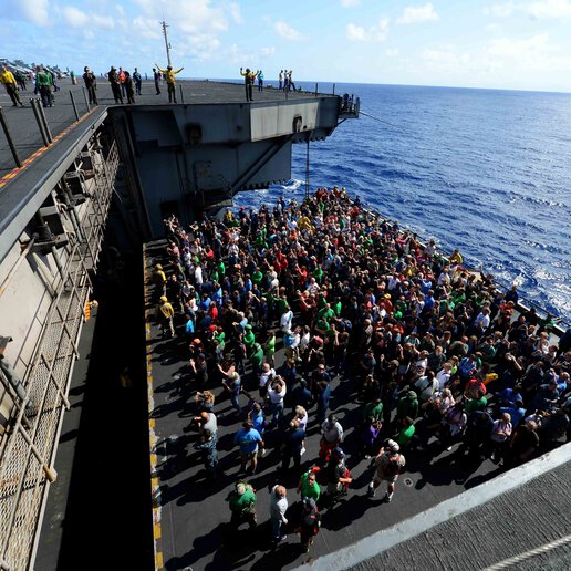 Sailors and personnel on a marine aircraft elevator.