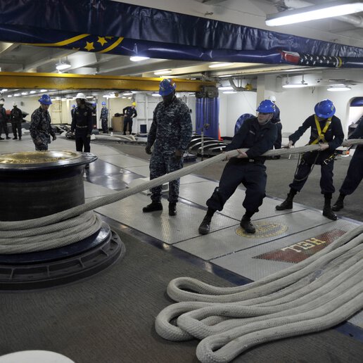 Sailors aboard the Nimitz-class aircraft carrier USS Harry S. Truman (CVN 75) securing a line to the capstan.