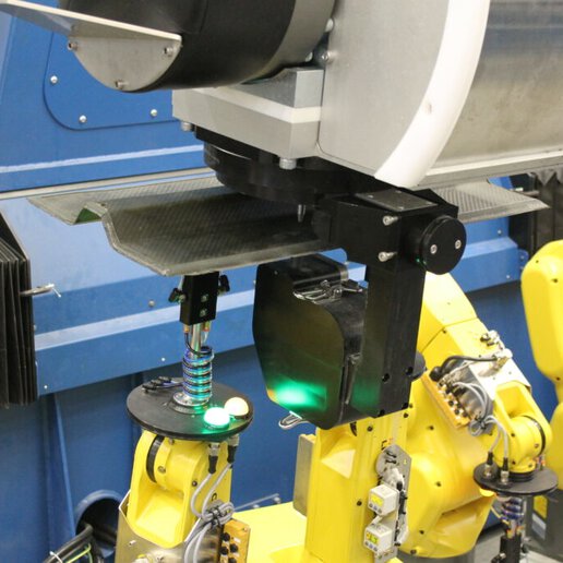 Configurable fixture performing waterjet cutting on a carbon fiber part.