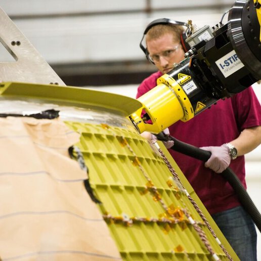 Equipment operator running I-STIR friction plug welding equipment.
