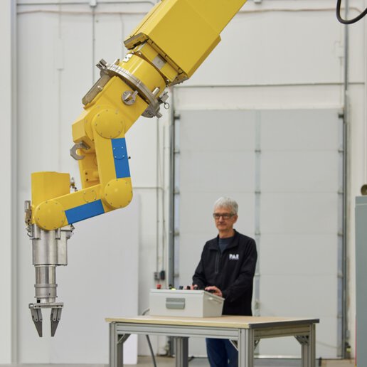 Manipulator operator standing behind a PAR radiation hardened manipulator.