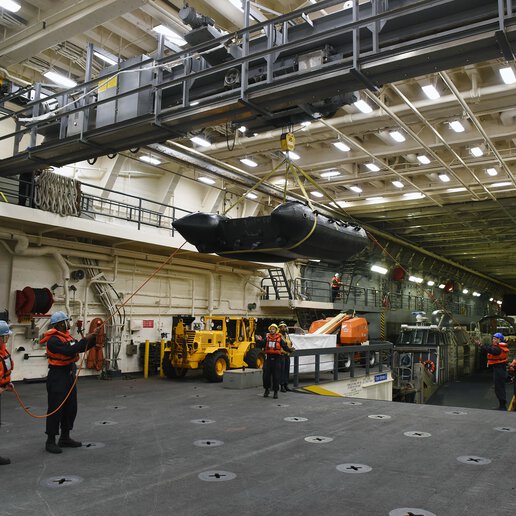 Sailors onboard amphibious transport dock ship USS San Diego (LPD 22) using the well deck bridge crane.
