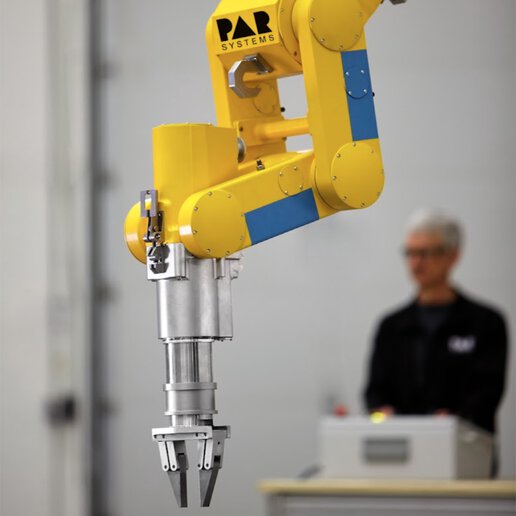 Operator behind radiation hardened manipulator arm.