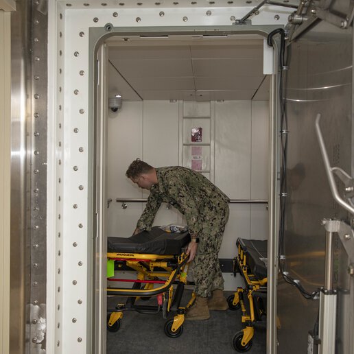 Hospital Corpsman 3rd Class adjusting gurney in an elevator onboard the transport ship USNS Cody (T-EPF 14).