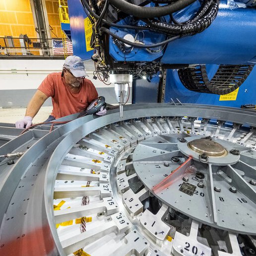 Operator monitoring friction stir welding machine preparing to weld.