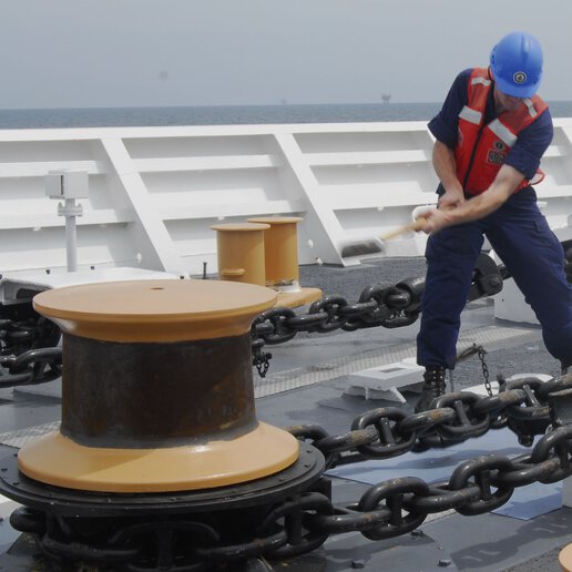 Petty officer freeing anchor chain from the safety pelican