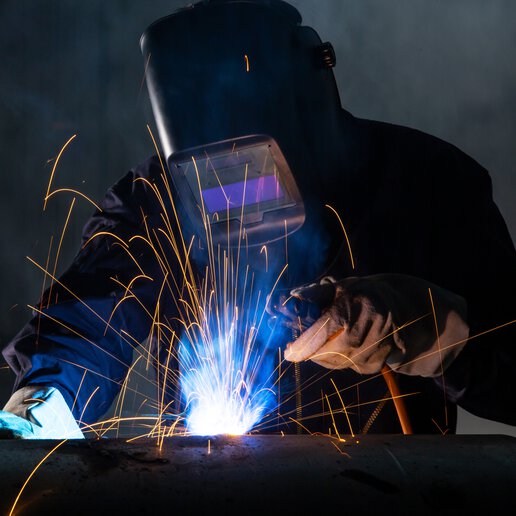 Welder welding with sparks flying in front.