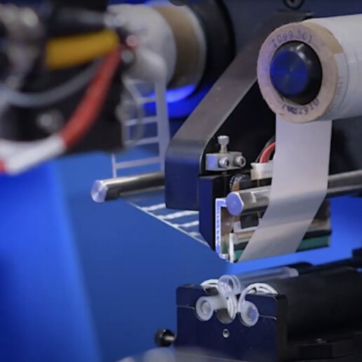 Labeling machine placing labels on tubes